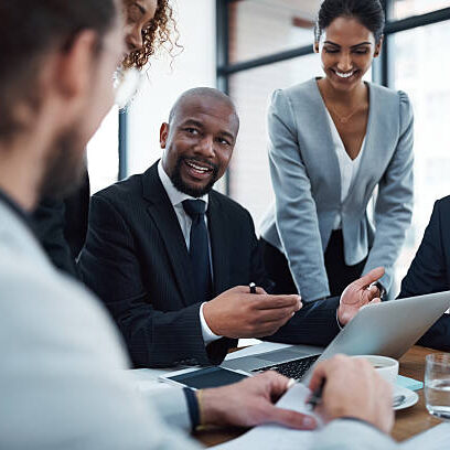 Shot of a group of businesspeople discussing something on a laptop